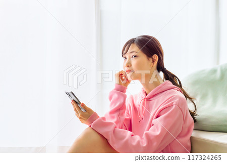 一個操作智能手機的年輕女子 117324265