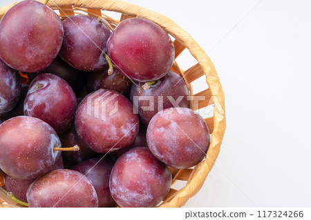 Basket of ripe plums isolated on white background, top view 117324266