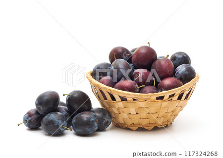 Basket of ripe plums isolated on white background 117324268