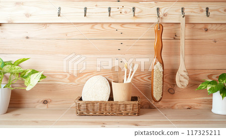 Eco friendly bamboo toothbrush and hair brush and loofah on wooden counter 117325211