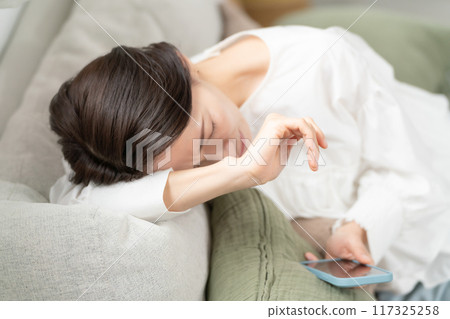 一位女士看著她的智慧型手機感嘆道 一位女士看著她的智慧型手機感嘆道 117325258