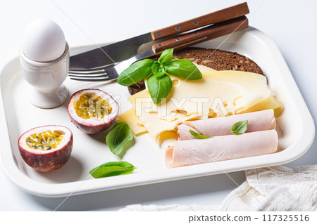 Ham, cheese, bread and boiled egg breakfast plate, white background. 117325516