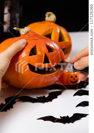 Creating a Hokkaido pumpkin jack-o'-lantern for Halloween. Creating a Hokkaido pumpkin jack-o'-lantern for Halloween. 117326360