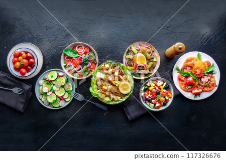 Fresh salads, overhead flat lay shot of an assortment. Variety of plates 117326676