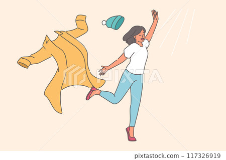 Woman takes off winter clothes and runs towards sun rays, rejoicing at onset of summer or warming 117326919