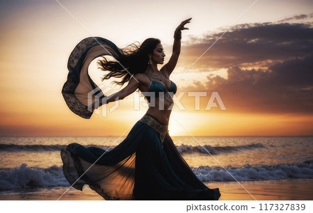 Belly dancer performing on the beach at sunset with flowing dress 117327839