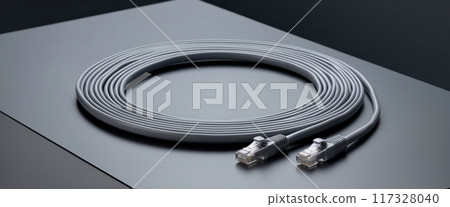 Grey ethernet cable lying on a metallic surface forming a circle 117328040