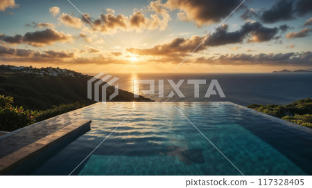 Infinity pool overlooking tranquil ocean at sunset with golden sky 117328405
