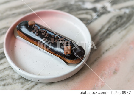 Classic French chocolate eclair recipe on marble table in cafe 117328987