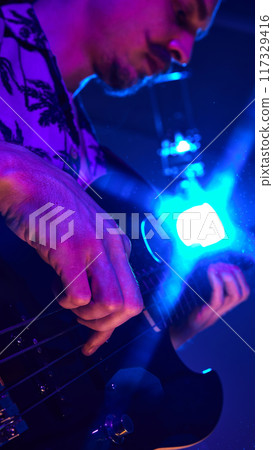 Fingers skillfully pluck strings of electric guitar under neon lights, showcasing dynamic energy of live music in stunning detail. Fingers skillfully pluck strings of electric guitar under neon lights, showcasing dynamic energy of live music in stunning detail. 117329416
