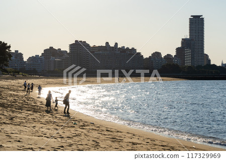 People playing in the sea in the evening 117329969