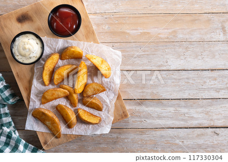 Fried potato wedges wooden table. Top view. Copy space Fried potato wedges wooden table. Top view. Copy space 117330304