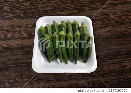 fresh okra pods on white background, vibrant green colour, inviting texture. crisp & delicious, perfect for culinary creations. fresh okra pods on white background, vibrant green colour, inviting texture. crisp & delicious, perfect for culinary creations. 117330371