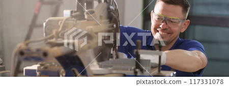 Man carpenter working in protective glasses using special equipment 117331078