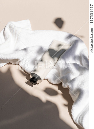 White metal cream tube mockup for care products on white towel in plant shadows White metal cream tube mockup for care products on white towel in plant shadows 117331417