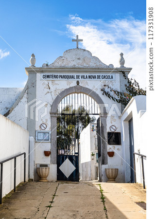The cemetery of Cacela Velha in southern Portugal. White facades of houses with colored decorations. The cemetery of Cacela Velha in southern Portugal. White facades of houses with colored decorations. 117331908