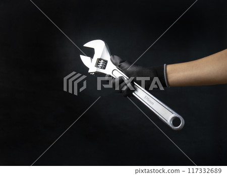 Mechanic holding a large adjustable wrench Size 375 mm Mechanic holding a large adjustable wrench Size 375 mm 117332689