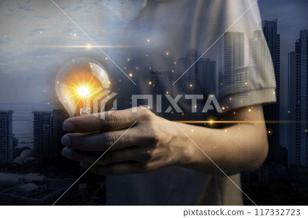 Concept. A man holds a light bulb. New ideas with innovative technology and creativity. Create a concept with a sparkling light bulb. Concept. A man holds a light bulb. New ideas with innovative technology and creativity. Create a concept with a sparkling light bulb. 117332723