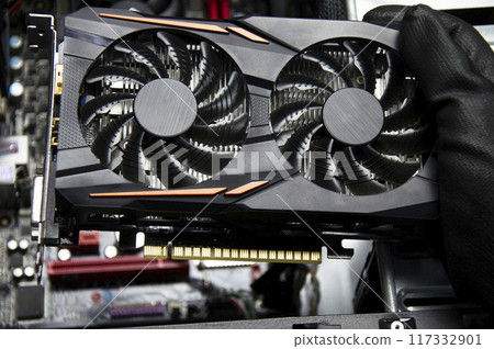Top view of a graphics card being held by a technician, repairing a computer. 117332901