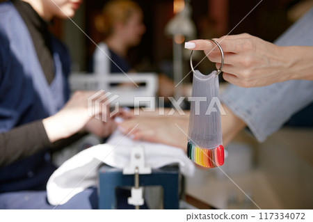 Closeup view on color palette with nail gel varnish for pedicure in client hand Closeup view on color palette with nail gel varnish for pedicure in client hand 117334072