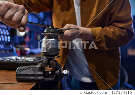 Mechanic disassembling and servicing bicycle internal-geared hub on vice 117334119