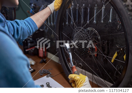 Young repairman removing speed cassette for examining and renovation 117334127