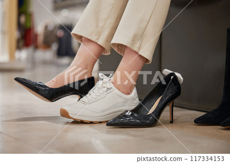 Shopping at footwear showroom concept, shot with female legs view 117334153