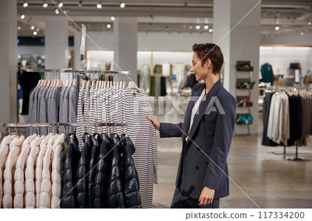 Cute businesswoman doing shopping at clothing department store Cute businesswoman doing shopping at clothing department store 117334200