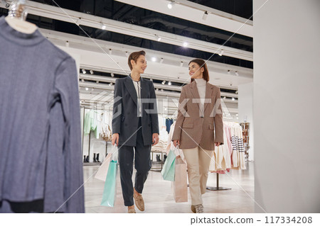 Young woman friends enjoying shopping together in big fashion shop mall 117334208