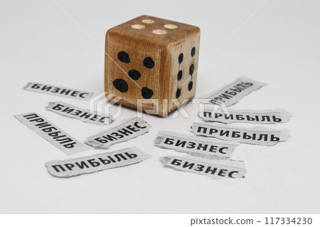 Newspaper clippings with the words business and profit in Russian and a dice, Cyrillic Newspaper clippings with the words business and profit in Russian and a dice, Cyrillic 117334230