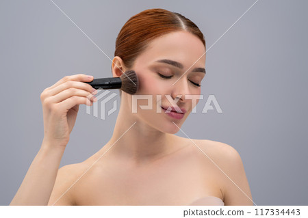 Young pretty woman doing make up and using face brush Young pretty woman doing make up and using face brush 117334443