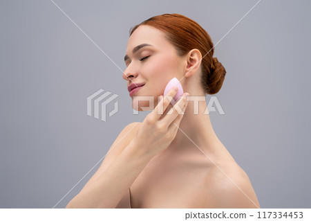 Ginger young woman with an absorbing sponge in hand Ginger young woman with an absorbing sponge in hand 117334453