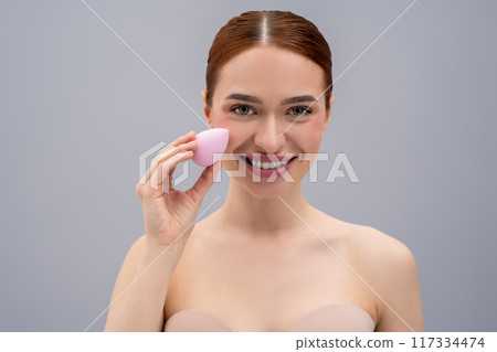 Pretty ginger caucasian woman using absorbing face sponge and smiling Pretty ginger caucasian woman using absorbing face sponge and smiling 117334474