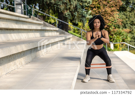Woman exercising outdoors and looking concentrated and focused 117334792