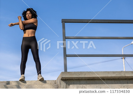 Slim fit black-haired woman stretching in the fresh air 117334830