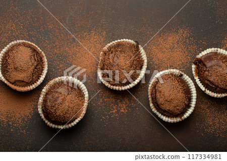 Chocolate and cocoa browny muffins top view on brown rustic stone background, sweet homemade dark chocolate cupcakes Chocolate and cocoa browny muffins top view on brown rustic stone background, sweet homemade dark chocolate cupcakes 117334981
