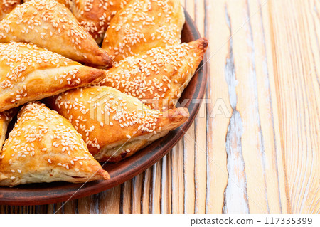 Homemade triangle puff pastry with meat on rustic background . Samosa Homemade triangle puff pastry with meat on rustic background . Samosa 117335399