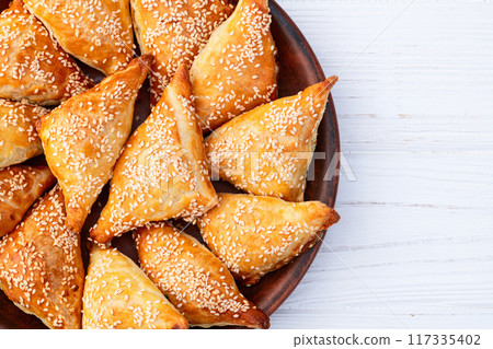 Homemade triangle puff pastry with meat on rustic background . Samosa Homemade triangle puff pastry with meat on rustic background . Samosa 117335402