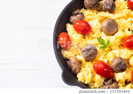 Healthy vegetarian breakfast . Scrambled eggs in pan with cherry tomatoes and parsley Healthy vegetarian breakfast . Scrambled eggs in pan with cherry tomatoes and parsley 117335443