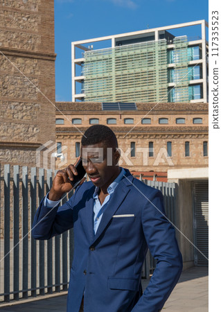 portrait of a business black man outdoor talking on the phone portrait of a business black man outdoor talking on the phone 117335523