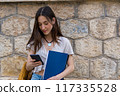 young woman with folder an a smartphone 117335528