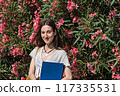 female florist with clipboard in flower garden 117335531