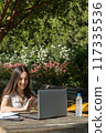 working on a laptop at the park in a beautiful day 117335536
