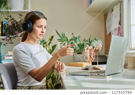 Girl teenage student in headphones having video chat online on computer 117335794