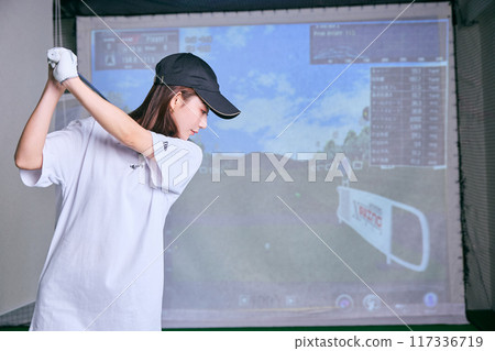 一名女子在室內高爾夫練習場練習 117336719