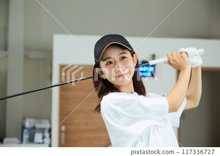 一名女子在室內高爾夫練習場練習 117336727