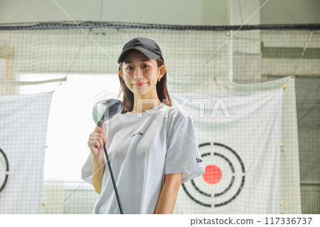 一名女子在室內高爾夫練習場練習 117336737