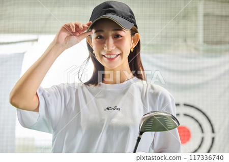一名女子在室內高爾夫練習場練習 一名女子在室內高爾夫練習場練習 117336740