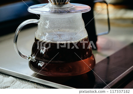 Coffee poured into a glass server Coffee poured into a glass server 117337182