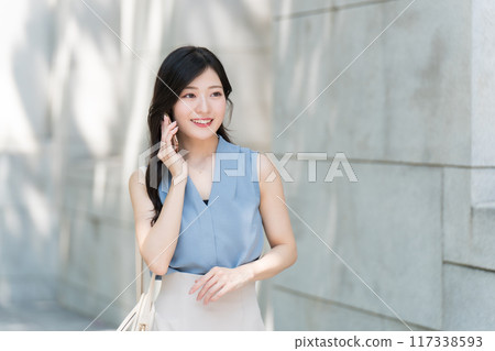 Business woman calling with a smartphone Business woman calling with a smartphone 117338593